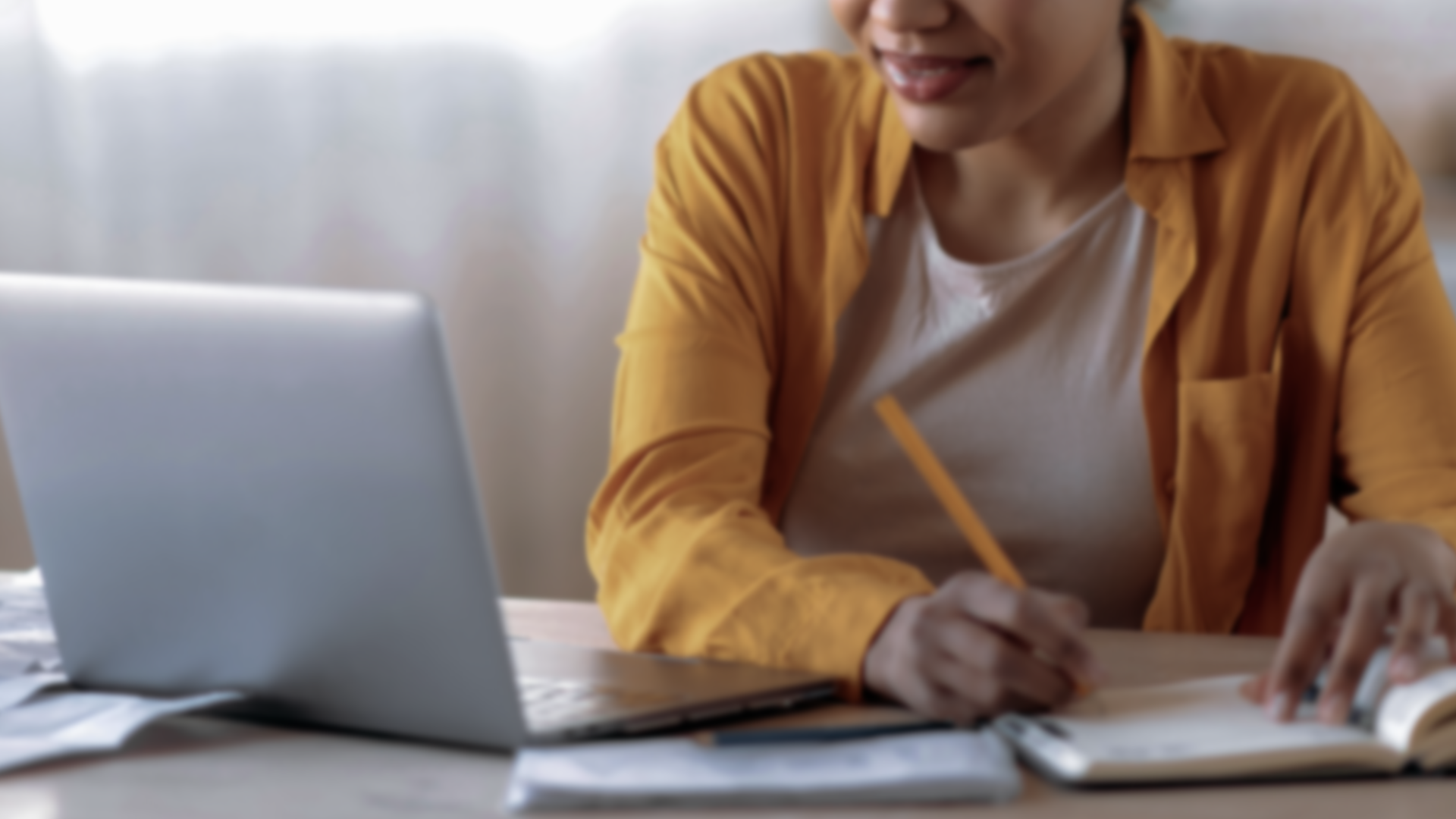 Learner studying online with a laptop and notebook